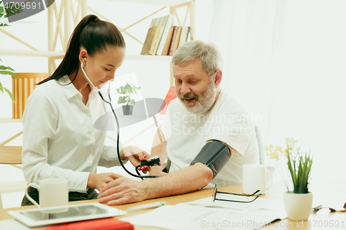 Image of The visiting nurse taking care of senior man