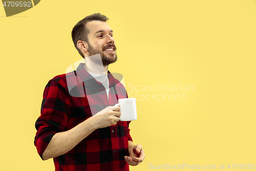Image of Half-length close up portrait of young man on yellow background.