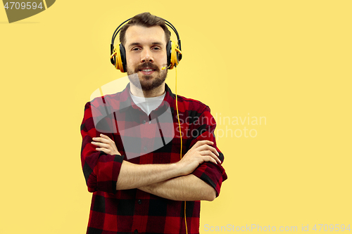 Image of Half-length close up portrait of young man on yellow background.