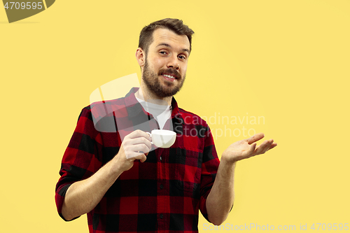 Image of Half-length close up portrait of young man on yellow background.