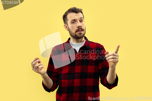 Image of Half-length close up portrait of young man on yellow background.