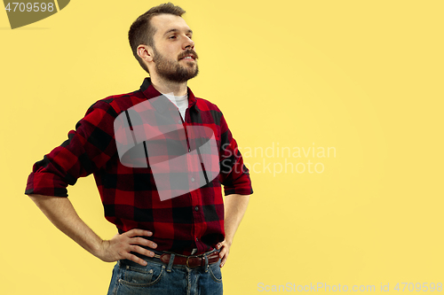 Image of Half-length close up portrait of young man on yellow background.