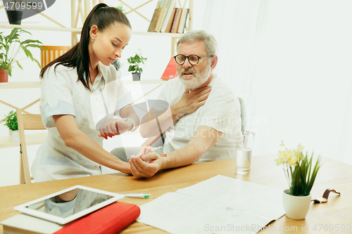 Image of The visiting nurse taking care of senior man