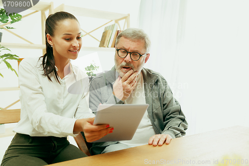 Image of A daughter or granddaughter spends time with the grandfather