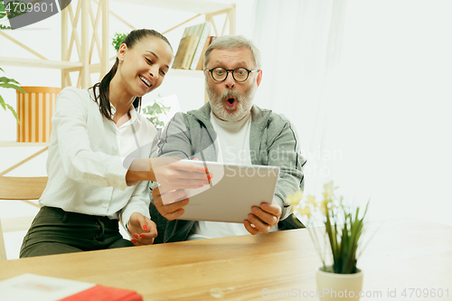 Image of A daughter or granddaughter spends time with the grandfather