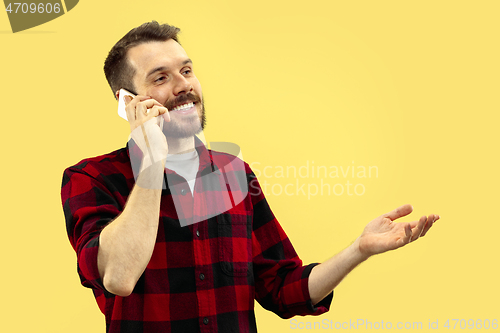 Image of Half-length close up portrait of young man on yellow background.