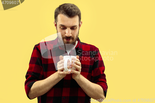 Image of Half-length close up portrait of young man on yellow background.