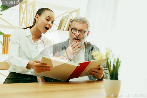 Image of A daughter or granddaughter spends time with the grandfather