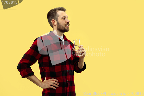 Image of Half-length close up portrait of young man on yellow background.