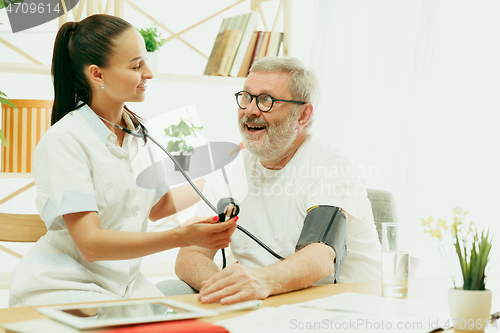 Image of The visiting nurse taking care of senior man