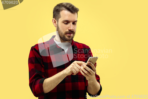 Image of Half-length close up portrait of young man on yellow background.