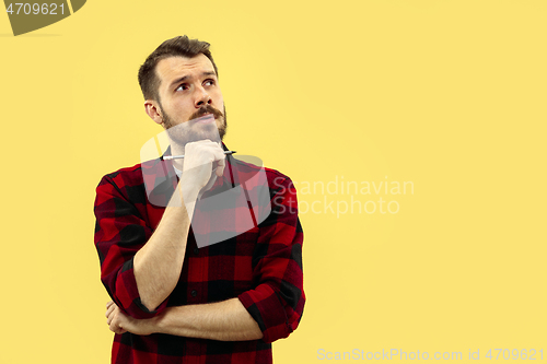 Image of Half-length close up portrait of young man on yellow background.