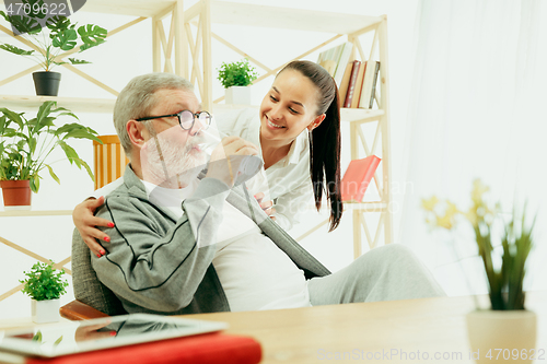 Image of A daughter or granddaughter spends time with the grandfather