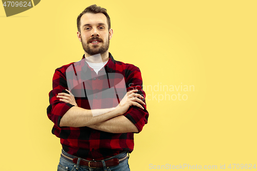 Image of Half-length close up portrait of young man on yellow background.