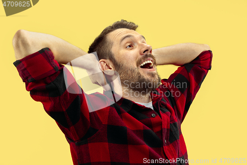 Image of Half-length close up portrait of young man on yellow background.