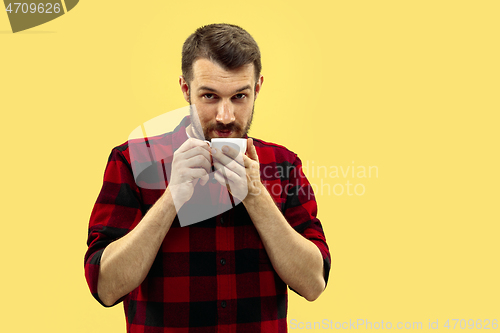 Image of Half-length close up portrait of young man on yellow background.