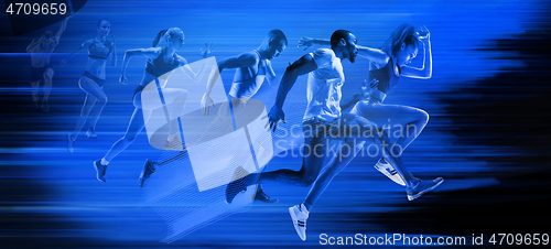 Image of Young african-american and caucasian men and women running isolated on blue studio background