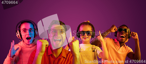 Image of Beautiful male and female models in neon light isolated on purple studio background