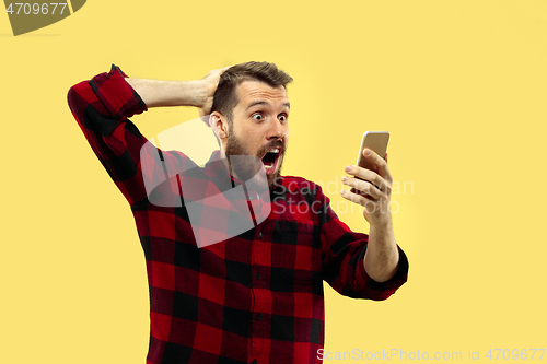 Image of Half-length close up portrait of young man on yellow background.
