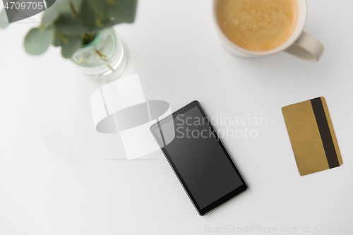 Image of smartphone, credit card and cup of coffee