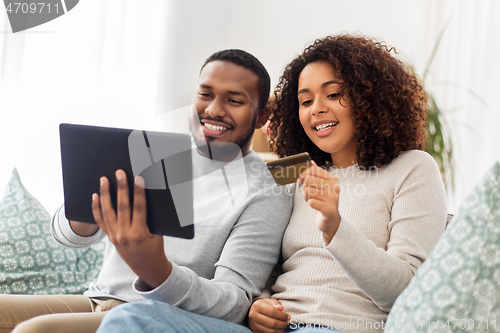 Image of couple with tablet pc and credit card at home