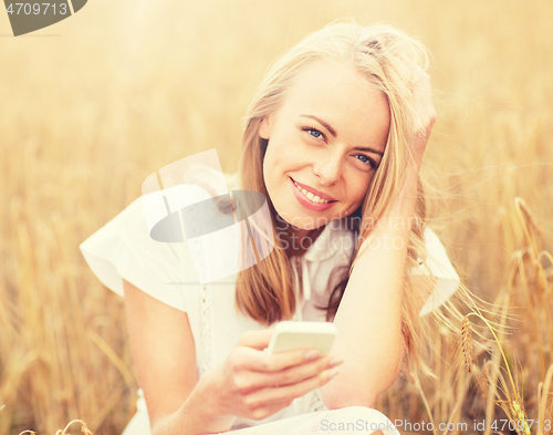 Image of happy young woman with smartphone on cereal field