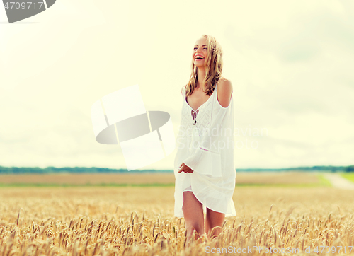 Image of smiling young woman in white dress on cereal field