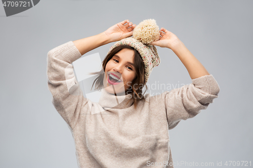 Image of young woman in knitted winter hat and sweater