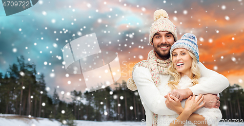 Image of smiling couple in winter clothes hugging