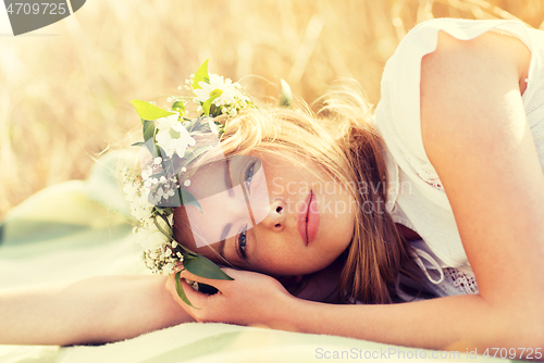 Image of happy woman in wreath of flowers on cereal field