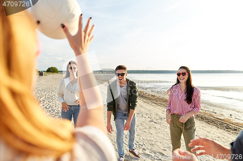 Image of friends playing volleyball on beach in summer