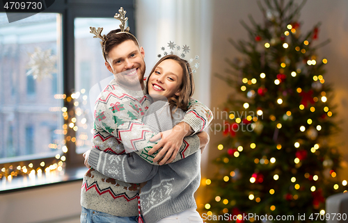 Image of happy couple at christmas ugly sweater party