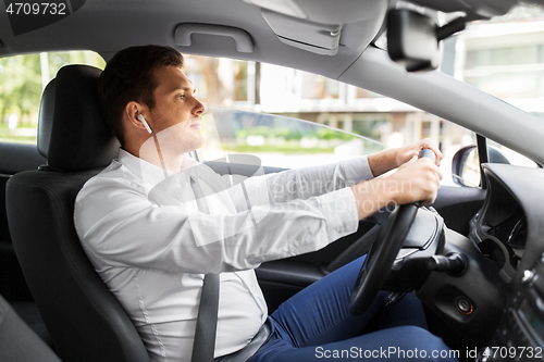 Image of man or driver with wireless earphones driving car