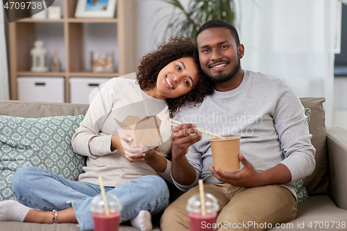 Image of happy couple with takeaway food and drinks at home