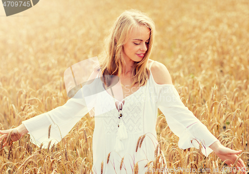 Image of smiling young woman in white dress on cereal field