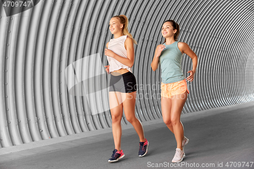 Image of young women or female friends running outdoors