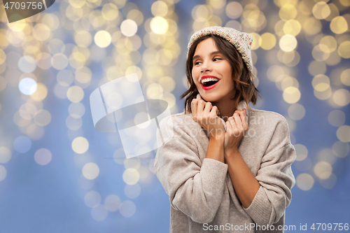 Image of young woman in winter hat and sweater on christmas