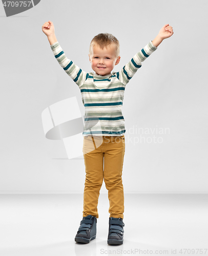 Image of happy little boy with raised hands