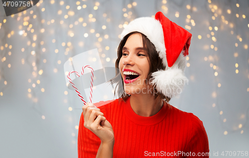 Image of happy young woman in santa hat on christmas