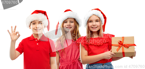 Image of children in santa helper hats with christmas gift