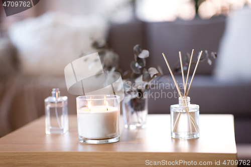 Image of aroma reed diffuser, burning candle and perfume