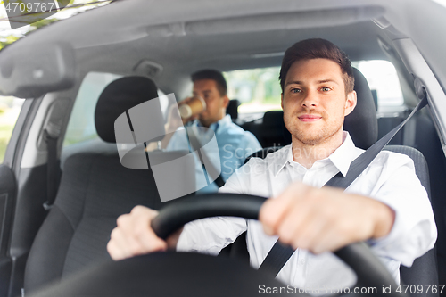 Image of male driver driving car with passenger