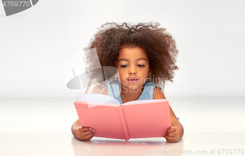 Image of happy little african girl reading book