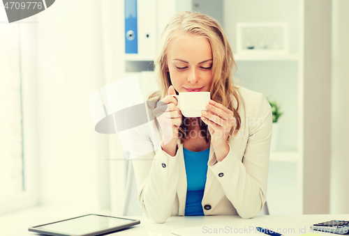 Image of happy businesswoman drinking coffee at office