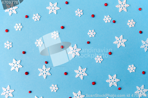 Image of white snowflakes and berries on blue background