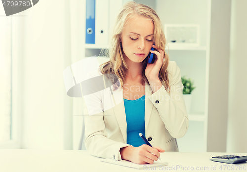 Image of businesswoman calling on smartphone at office