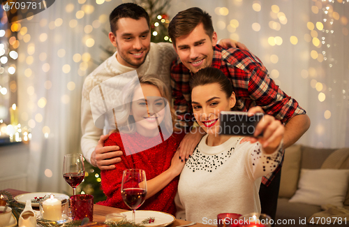 Image of friends taking selfie at christmas dinner