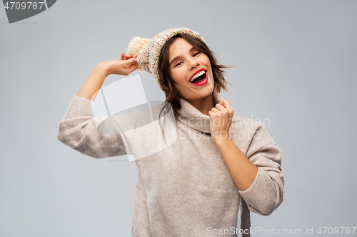 Image of young woman in knitted winter hat and sweater