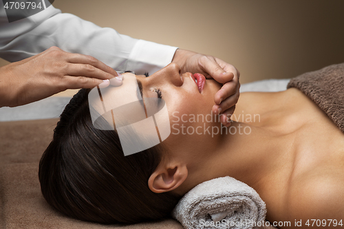 Image of woman having face and head massage at spa