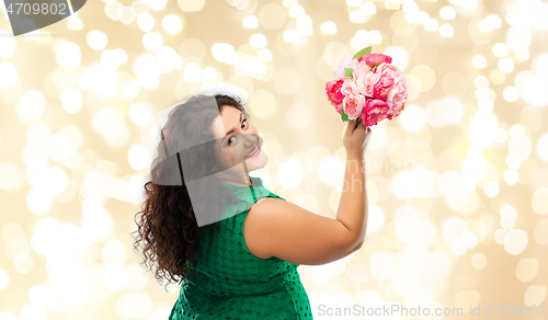 Image of happy woman in green dress with flower bunch